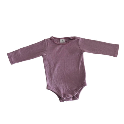A long-sleeve baby bodysuit in a dusty mauve-purple color, laid flat on a white fabric background.