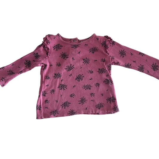 Cotton On Age 1 long sleeved t-shirt in pink, black with floral cluster print, frill trim at sleeves and neckline, snap buttons at back — like new condition.