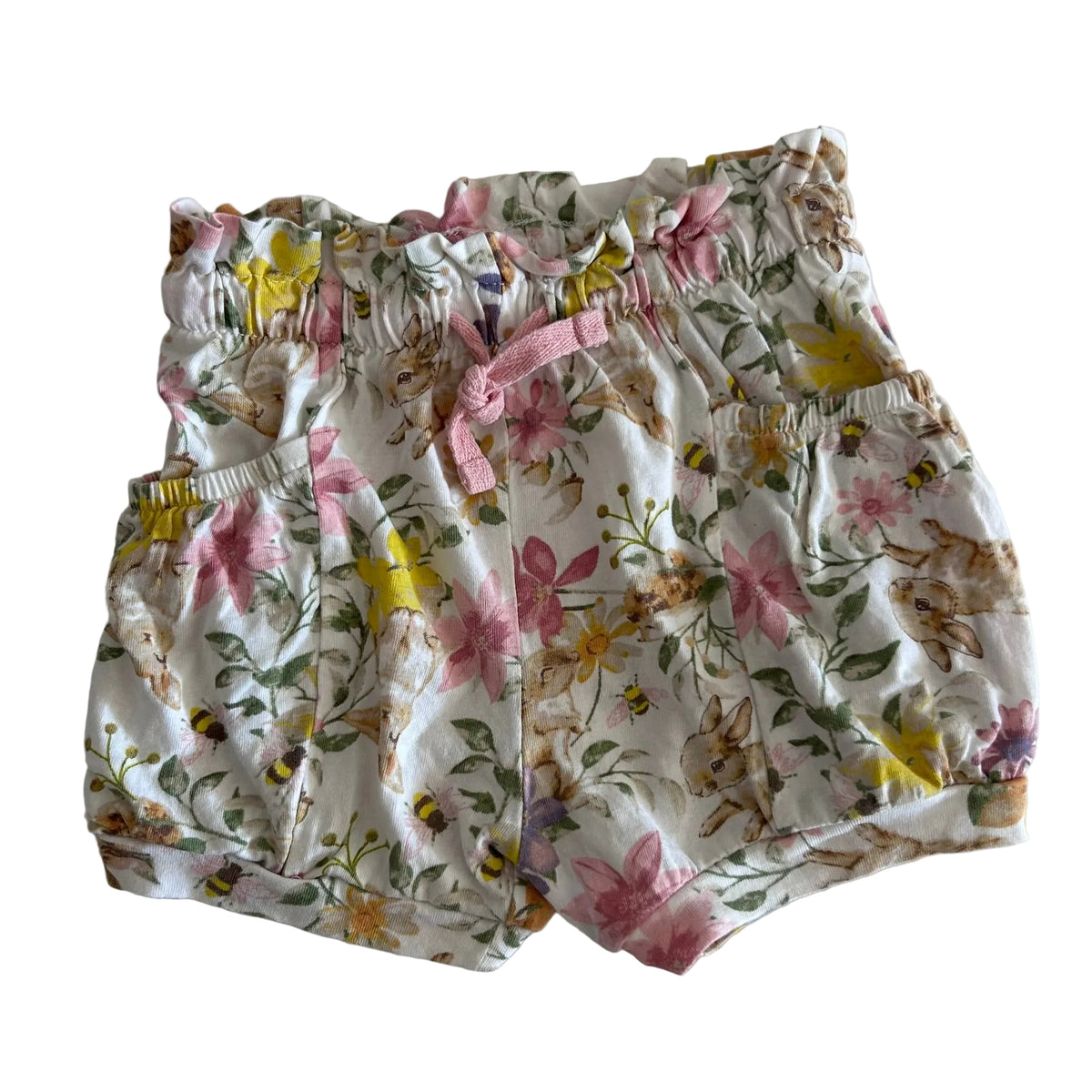 A pair of baby bloomers with a white background and a colorful print of bunnies, flowers, and bees, featuring a pink drawstring waist.