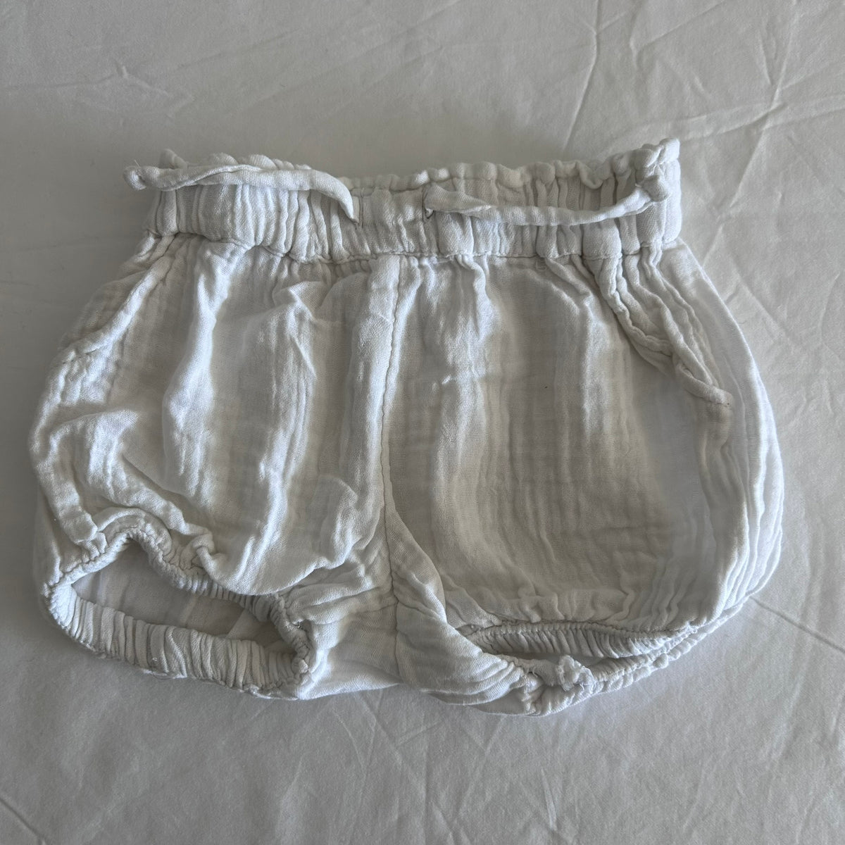 Anko Age 0 bloomer shorts in white with subtle texture, elasticated waist with drawstring, elasticated leg openings — gently loved condition.