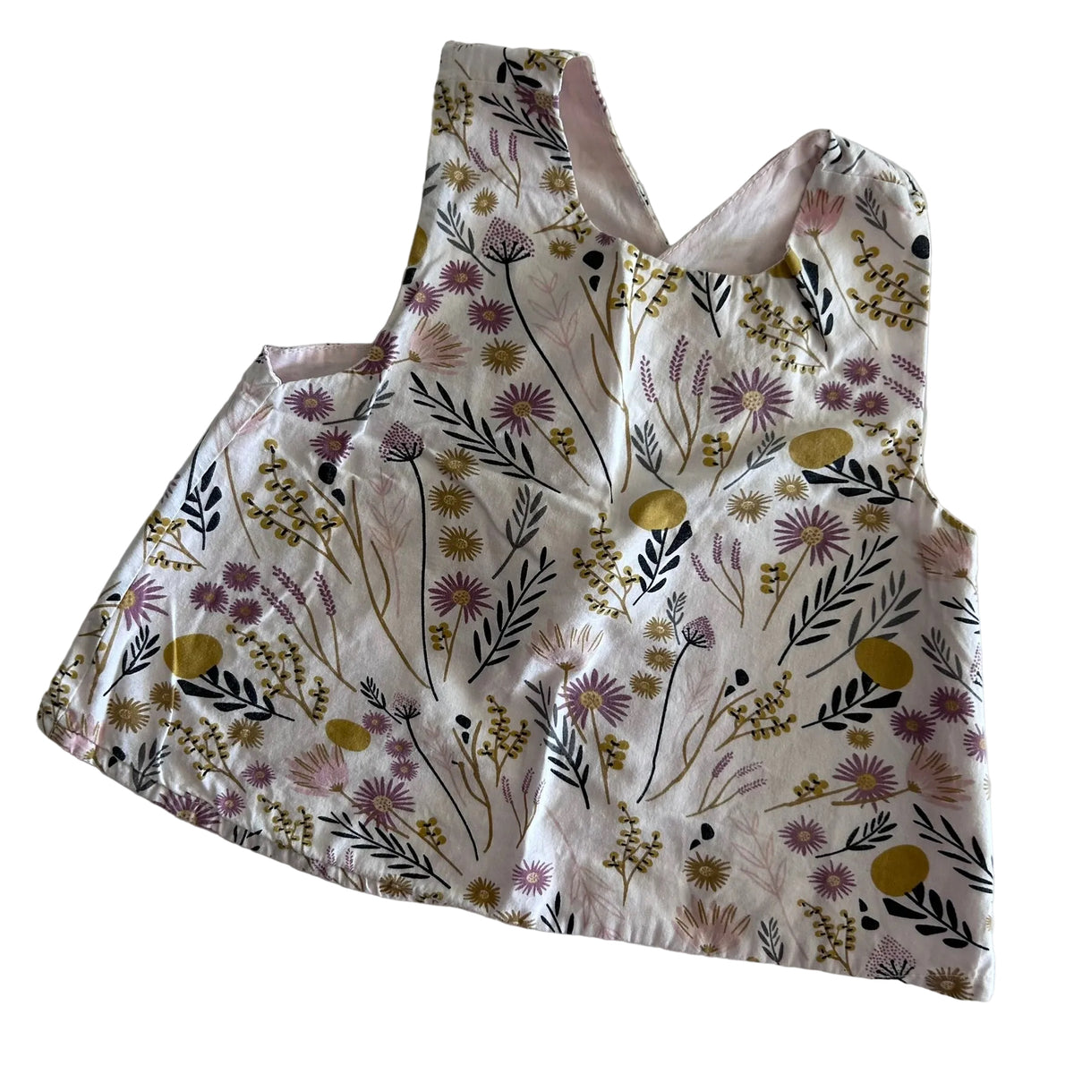 Not branded Age 1 sleeveless pinafore top in white, pink, mustard yellow, purple, black with floral botanical print with wildflowers, leaves, and stems — gently loved condition.