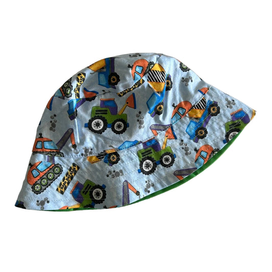 Satin & Stripes Age 00 reversible bucket hat in light blue, green, orange, yellow, purple with construction vehicles and trucks print on one side, solid green on reverse, topstitched brim — like new condition.