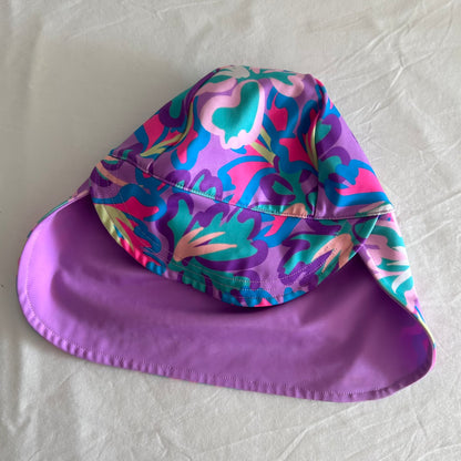 Bonds Age 0 swim sun hat with neck flap in purple, pink, teal, blue, yellow-green with abstract floral print on outer; solid lilac/purple on inner brim — like new condition.
