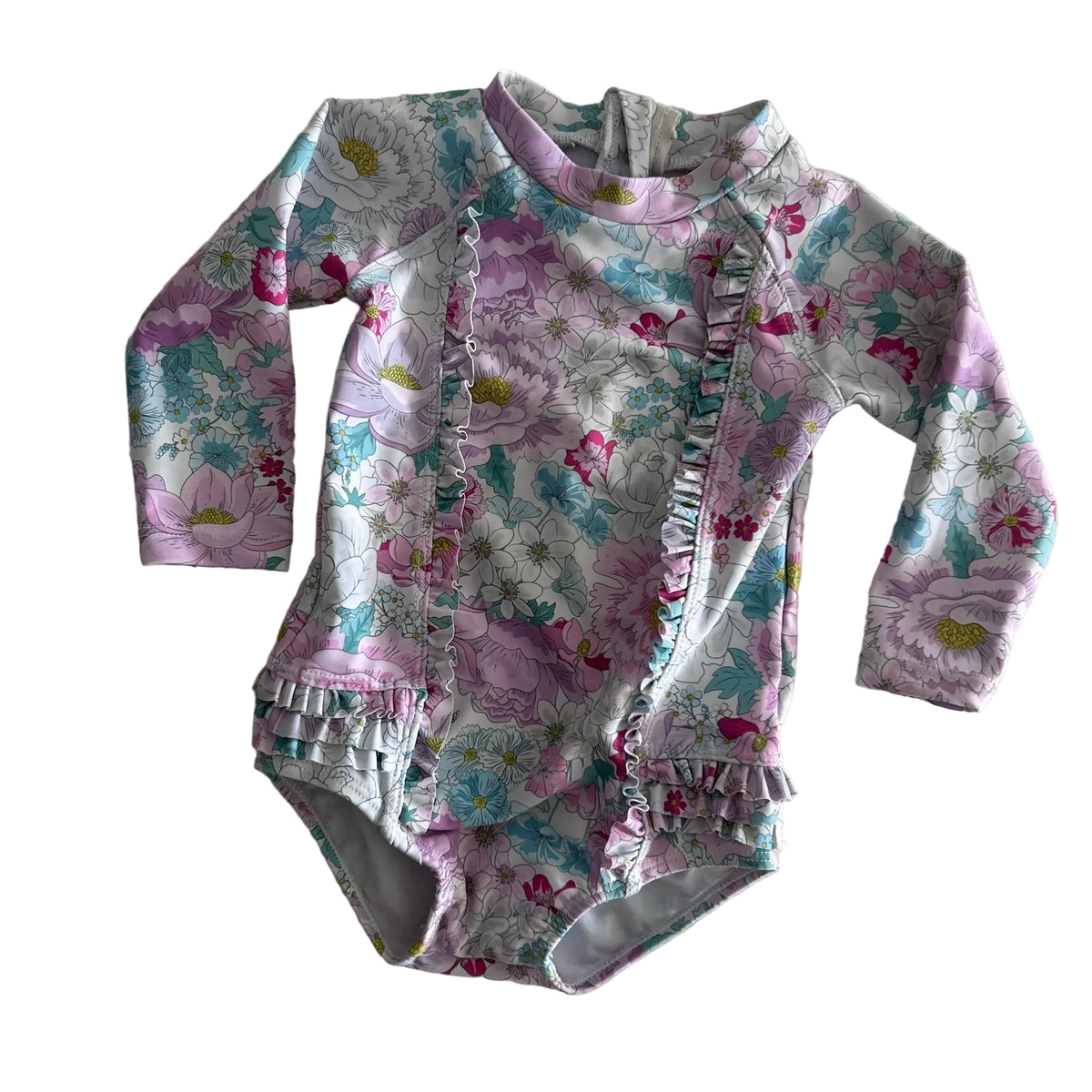 Bebe by Minihaha Age 00 long sleeve zip-up swimsuit / rashie one-piece in white, pink, lilac, teal with floral print with ruffle trim on front, hem and leg openings — gently loved condition.