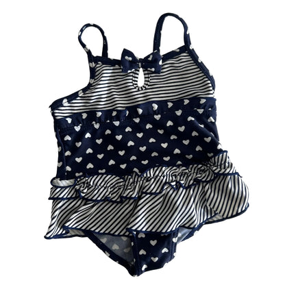 Hippo + Friends Age 0 one-piece swimsuit in navy blue and white with mixed heart print and stripe print with tiered ruffle skirt and bow detail — gently loved condition.