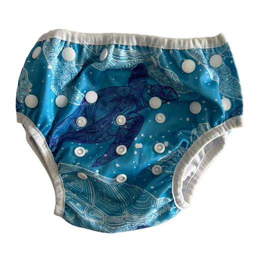 Waladi Age 00 reusable swim nappy in teal, white, navy blue with sea turtle print with mandala/zentangle detail, bubble spots, snap button closures — gently loved condition.
