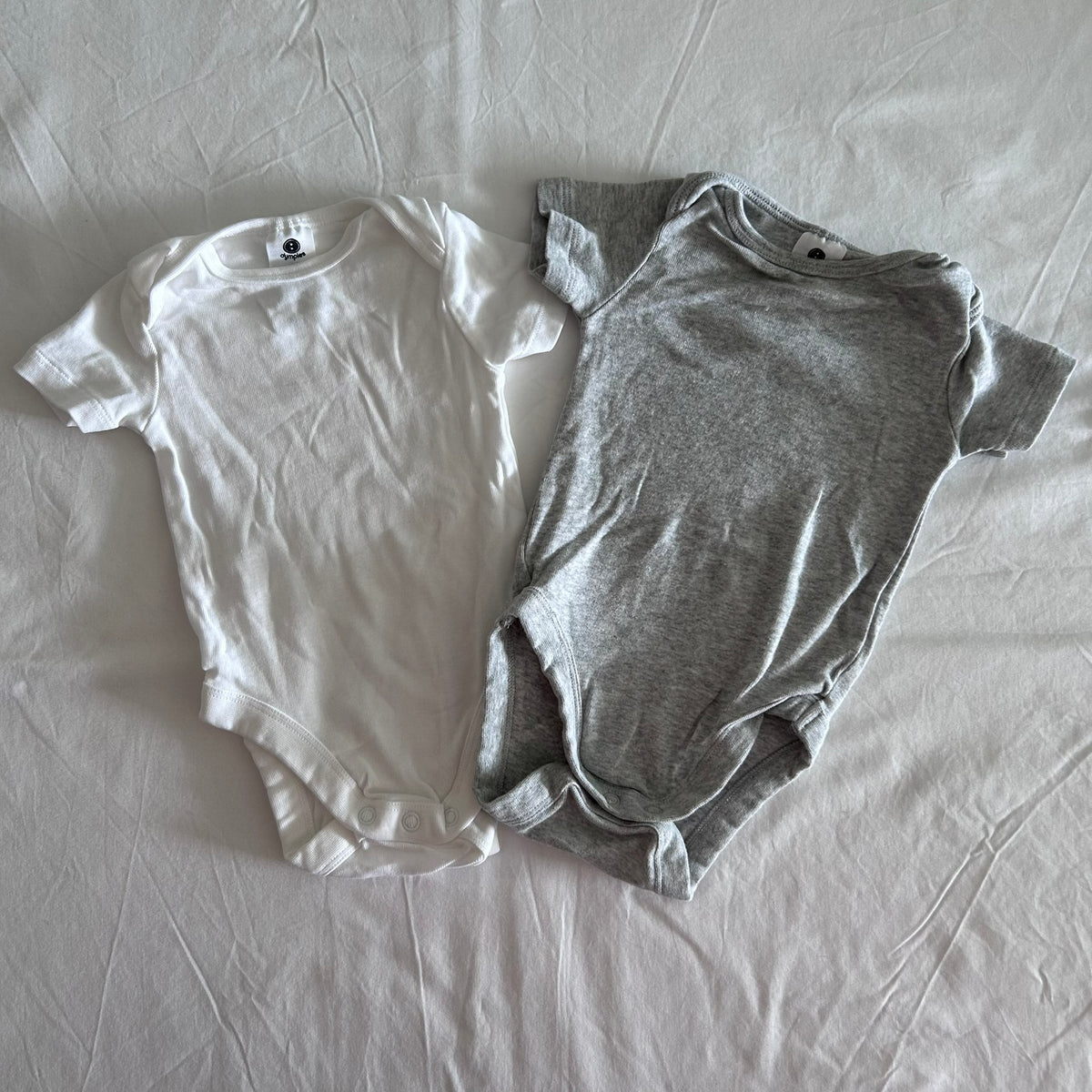 Dymples Age 00 short sleeve bodysuit in white with plain — like new condition.