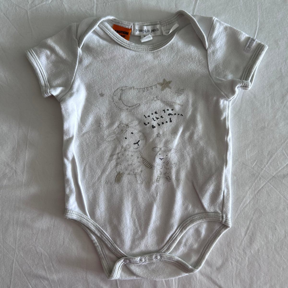Pumpkin Patch Age 00 short sleeve snap-crotch bodysuit in white with printed illustration of two sheep/bears with moon, stars and bunting; text reads 'love you to the moon & back' — gently loved condition.