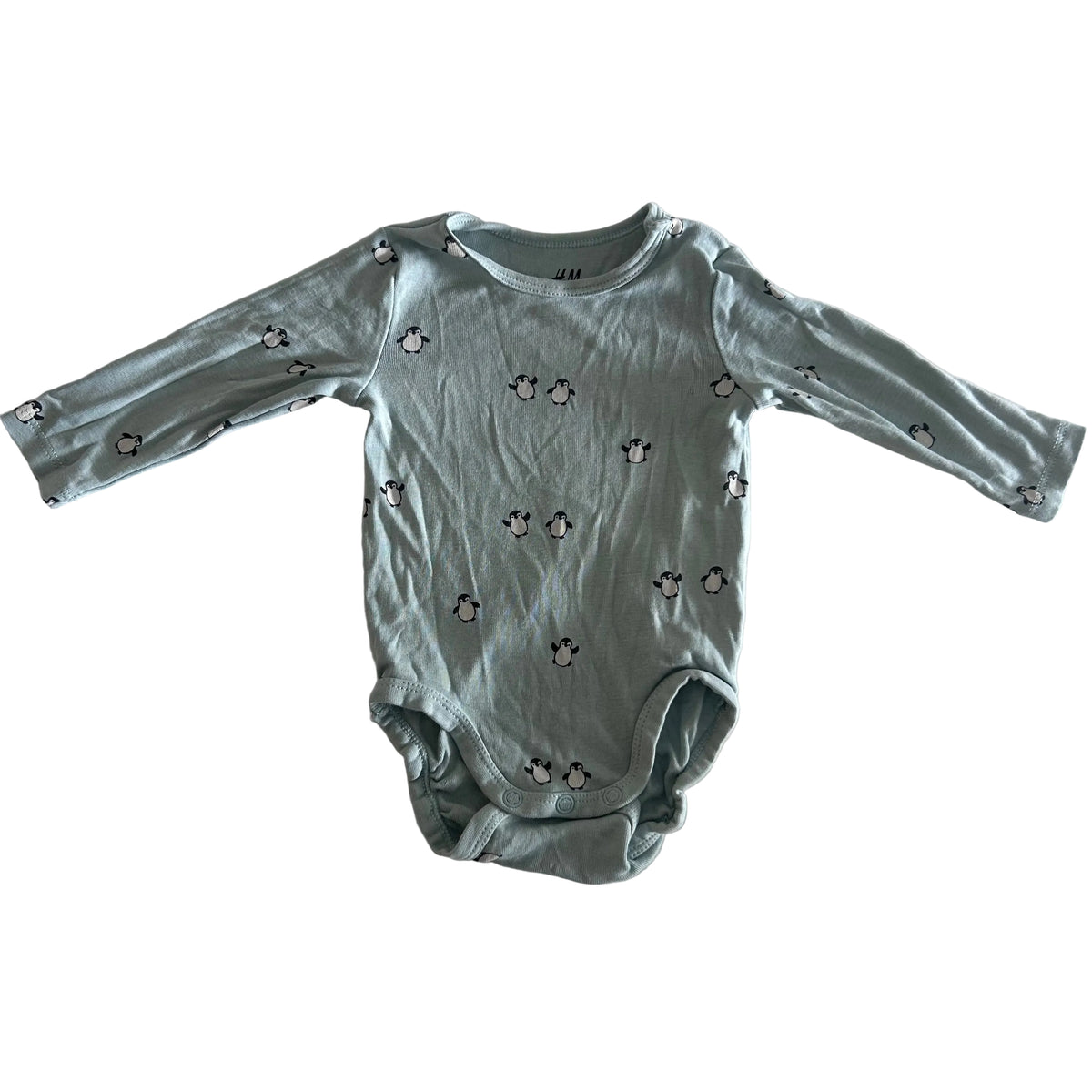 H&M Age 000 long sleeve bodysuit in light green with allover penguin print — gently loved condition.
