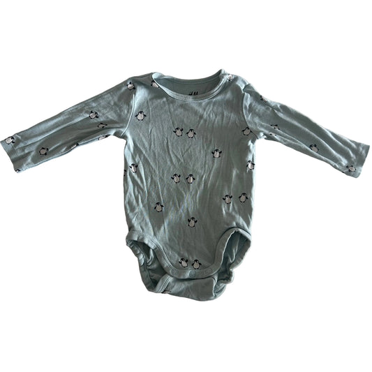 H&M Age 000 long sleeve bodysuit in light green with allover penguin print — gently loved condition.
